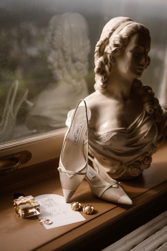 Trouwen in een kasteel: Elegante kasteelbruiloft in de Ardennen, Bridal details voor het raam met Yves saint laurent luchtje en Jimmy Choo schoenen ,door artistieke bruidsfotograaf in Nederland